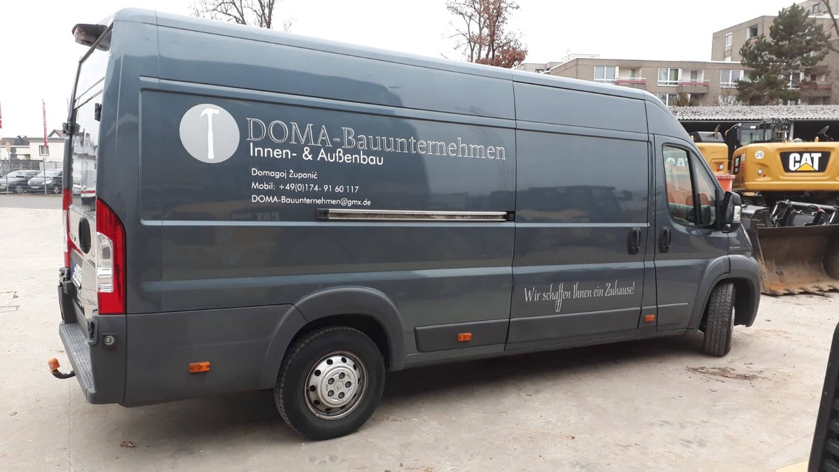Domabau-Transporter mit Firmenbeschriftung